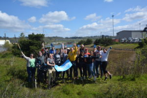 Group of volunteers hold 350 banner at salt marsh